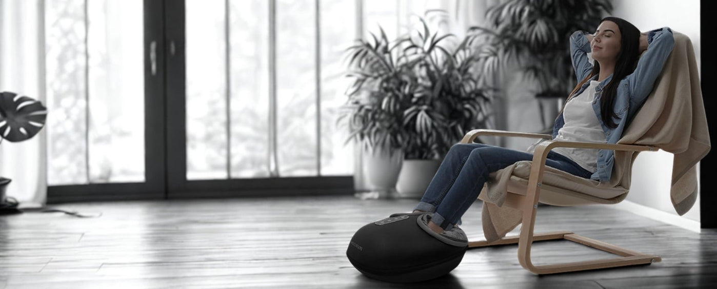 Woman relaxing in a modern chair in a bright room with large windows.